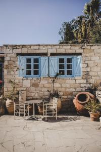 a table and chairs in front of a stone building at Cyprus Villages Hotel & Restaurant - Central Location - Bed & Breakfast - With Access To Pool And Stunning Views in Tochni