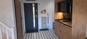 a kitchen with a blue door and a black and white floor at Domek pod Sosnową Górą 2 in Żelazno