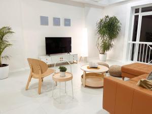 a living room with a couch and a tv at Beachside Sunset Oasis at Canyon Cove in Nasugbu