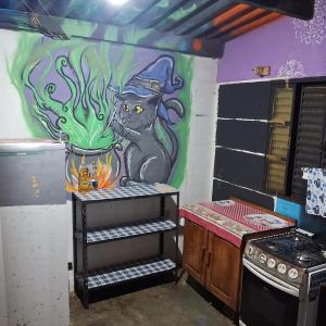 una cucina con un dipinto di un gatto sul muro di Camping em Casa João e Maria STL a São Thomé das Letras