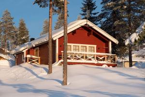 a red cabin in the snow with snow covered trees at Sauna | Wi-Fi | EV Dock | Pets OK in Lofsdalen