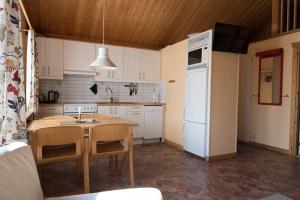 a kitchen with a table and a white refrigerator at Sauna | Wi-Fi | EV Dock | Pets OK in Lofsdalen