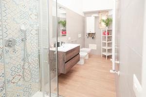 a bathroom with a sink and a glass shower at Vatican Museum Apartment in Rome +35 photos