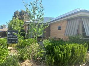 a garden with a sign in front of a building at HUNTER COTTAGE EUROA - "A great weekend escape" in Euroa