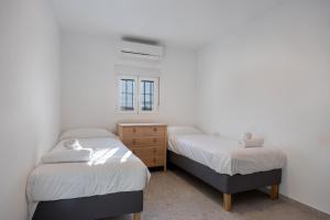 zwei Betten in einem Zimmer mit weißen Wänden in der Unterkunft Ático San Jose in Cádiz