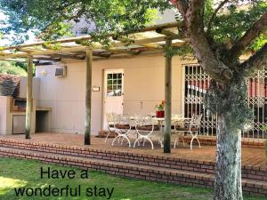 a patio with a table and chairs under a pergola at Rainbow Cottages - Kingfisher Drive in Sedgefield