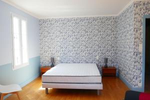 ein Schlafzimmer mit einem Bett und einer blau-weißen Wand in der Unterkunft Grande Maison 200m de la plage à Bretignolles Mer plus piscines partagées in Brétignolles-sur-Mer