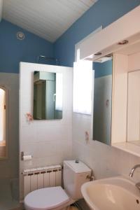 ein Badezimmer mit Toilette, Waschbecken und Spiegel in der Unterkunft Grande Maison 200m de la plage à Bretignolles Mer plus piscines partagées in Brétignolles-sur-Mer + 10 Fotos