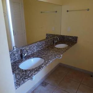 un bagno con 2 lavandini e un ripiano in granito di Chalés Confort 2 a Pimenta Altre 12 foto