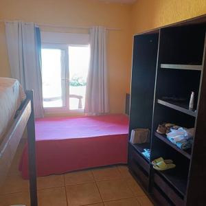 una camera da letto con un letto e una finestra di Chalés Confort 2 a Pimenta