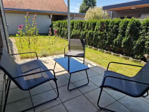 three chairs and a table on a patio at 10min zum CenterParcs, Bungalow mit Garten,Carport in Leutkirch im Allgäu
