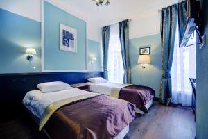 2 Betten in einem Zimmer mit blauen Wänden in der Unterkunft Petersburg's Elegy in Sankt Petersburg