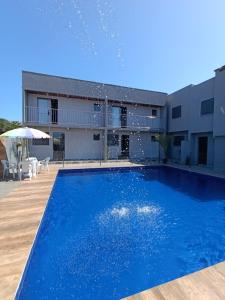 a large blue swimming pool in front of a building at Dk residêncial CASA INTEIRA in Pontal do Paraná +6 photos