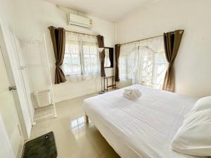 a bedroom with a white bed and a window at Cozy 3 BR house & green lawn near Airport & Old town in Chiang Mai
