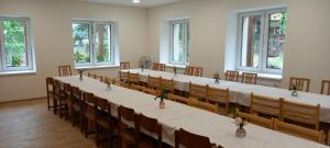 a row of tables in a room with windows at Turistická Ubytovňa Zádiel - Turistaszálló Szádelő in Zádiel