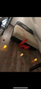a bed on the floor with red rose petals on it at La grange de Livia in Ferrière-la-Grande