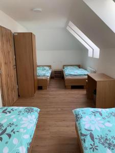 a room with three beds and cabinets in it at Turistická Ubytovňa Zádiel - Turistaszálló Szádelő in Zádiel