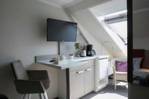 a kitchen with a sink and a tv on the wall at Gästehaus Orion - Einzelzimmer 11 in Spiekeroog