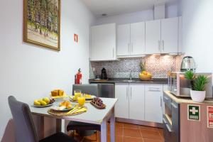 a kitchen with white cabinets and a table with fruit on it at Host Wise - Stylish Adorable Flat in Gaia in Vila Nova de Gaia +8 photos