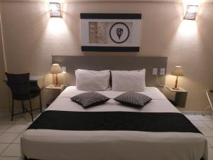 a bedroom with a large bed with two pillows at Palace Hotel Três Poderes in Frutal