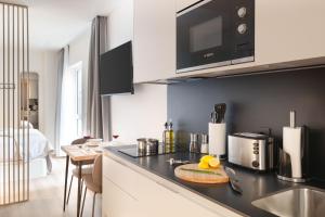 una cucina con piano di lavoro nero e lavandino di Limehome Madrid Calle de Juan Hurtado de Mendoza a Madrid