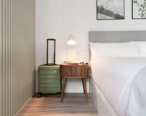 una camera con un letto e un tavolo con una valigia di Limehome Madrid Calle de Juan Hurtado de Mendoza a Madrid Altre 33 foto