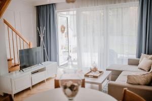 a living room with a flat screen tv and a couch at Domki Balticana in Władysławowo