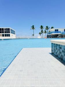 una piscina con agua azul y palmeras en Castle 1133 Ocean view studio, Pool and Beach Access, FREE Parking, Tennis and more!, en Miami Beach
