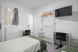 une chambre avec un lit, un bureau et une télévision dans l'établissement Coliving Mol-Terrace, En-Suite Bathroom, Fridge & TV, à Las Palmas de Gran Canaria