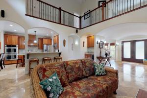 a living room with a couch and a kitchen at Blue Hawaii House in Princeville