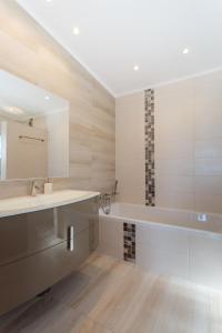 ein Badezimmer mit Waschbecken und Badewanne in der Unterkunft Casa Floresta - Fabulous villa in Poço Partido