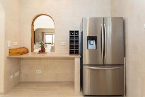 ein Edelstahlkühlschrank in einer Küche mit Theke in der Unterkunft Casa Floresta - Fabulous villa in Poço Partido