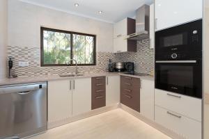 eine Küche mit weißen Schränken und einem Fenster in der Unterkunft Casa Floresta - Fabulous villa in Poço Partido