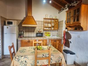 a kitchen with a table and a white refrigerator at Casa Rosiana in Santa Lucía