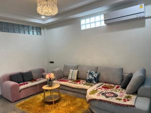 a living room with two couches and a table at Pani House Hatyai 5 in Hat Yai
