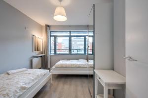 Un dormitorio con dos camas y un espejo. en Belfast City apartment with free parking!, en Belfast