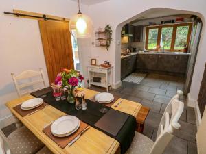 a dining room with a table and a kitchen at 100 Cwmphil Road in Swansea