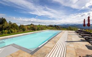 a swimming pool with chairs and umbrellas at Ferienwohnungen Appartements Bergwald in Scheidegg