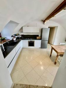 a kitchen with white cabinets and a wooden table at Corvina Suite in Costermano sul Garda