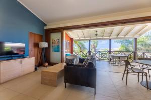 a living room with a couch and a tv at Tropical Escape with Pool and Ocean Views in Willemstad
