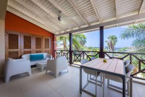 a room with a balcony with a table and chairs at Tropical Escape with Pool and Ocean Views in Willemstad