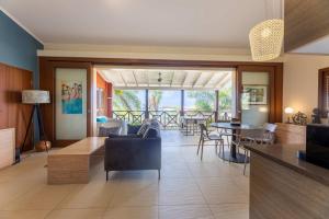 a living room with tables and chairs and a dining room at Tropical Escape with Pool and Ocean Views in Willemstad