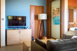 a living room with a couch and a flat screen tv at Tropical Escape with Pool and Ocean Views in Willemstad +27 photos