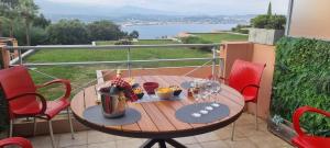 une table sur un balcon avec vue sur l'eau dans l'établissement 2 pièces vue panoramique sur mer et baie de Cannes, à Théoule-sur-Mer