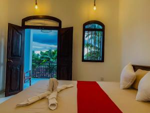 a bedroom with a bed with a red and white blanket at Surf View Point Ahangama in Ahangama