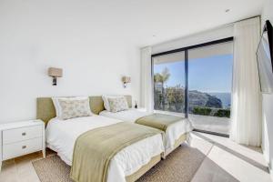 a bedroom with a bed and a large window at Villa Centeanes - Luxury villa in Carvoeiro +30 photos