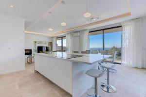 a kitchen with a white counter and some windows at Villa Centeanes - Luxury villa in Carvoeiro