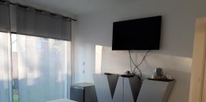 a living room with a flat screen tv on a wall at Love Room Glamour in Tremblay-En-France