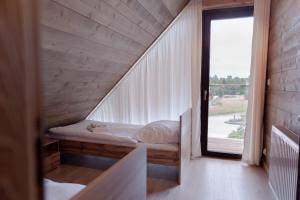 a room with a bed and a large window at Beskidzkie Wyspy in Tenczyn