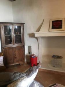 a living room with a cabinet and a red trash can at Les petits cyprès in Bonnieux